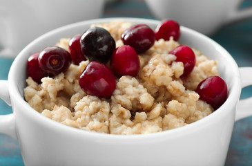 Tasty oatmeal with cherries in casserole, closeup