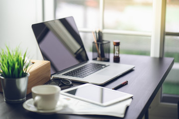 Top view desk of work table in office with laptop computer , notebook , calculator and a cup of...