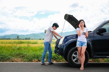 Asia couple traveler have a problem about car.beautiful lady calling to insurance to help and fix her broken car stop near the road during her travel on vacation.