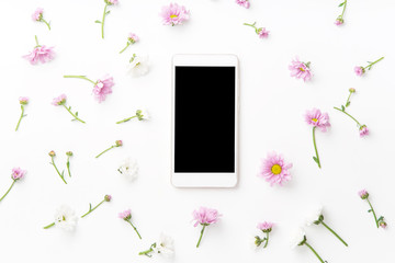 Flatlay with smartphone mock up and floral pattern at white background. Top view