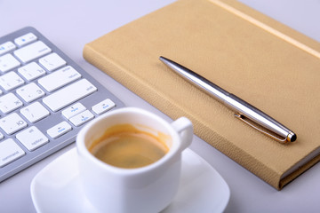 office table with notebook, computer keyboard,, cup of coffee, tablet pc. copy space.