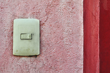 Plastic light switch box, vintage mexican door bell and red wall