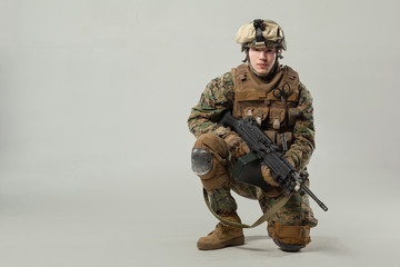 Soldier in camouflage holding rifle