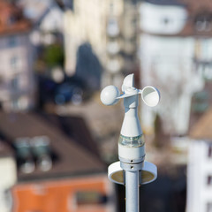 white anemometer with houses in background