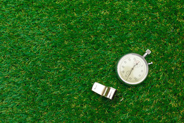 Silver chronometer on green grass