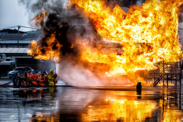 firefighter training., fireman using water and extinguisher to fighting with fire flame in an...
