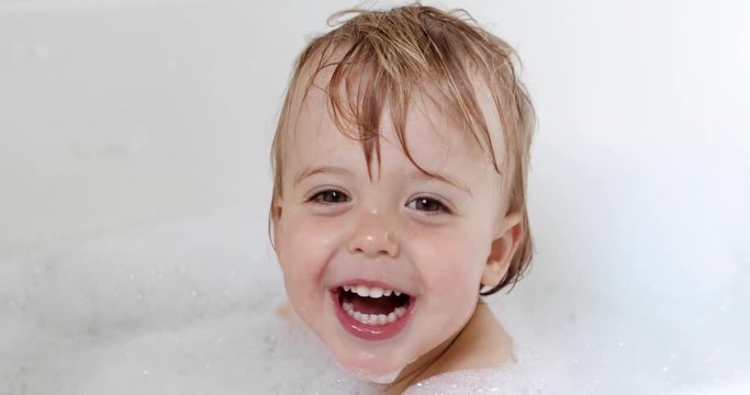 happy baby boy laughing and bathed in the bath tub