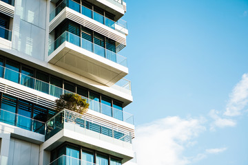The corner of the building with many windows against the blue sky