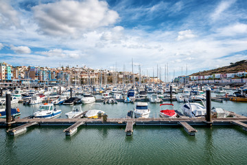 Fototapeta na wymiar Port in the bay of Albufeira, Portugal, many boats and yachts in the background of the city, a popular destination for travel and recreation in Europe