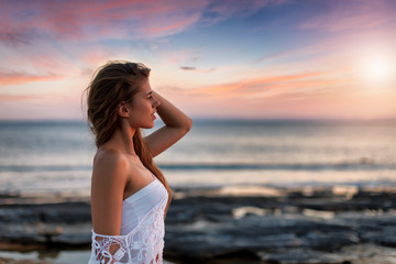 Fototapeta na wymiar Portraät einer attraktiven, blonden Frau am Meer bei Sonnenuntergang