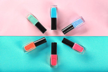 Obraz premium Bottles with nail polishes on color background