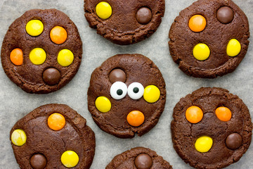 Halloween cookies, chocolate american cookies with chocolate orange and yellow candy, halloween treats for kids
