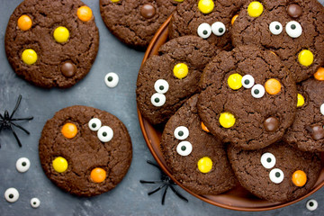 Halloween cookies, chocolate american cookies with chocolate orange and yellow candy, halloween treats for kids