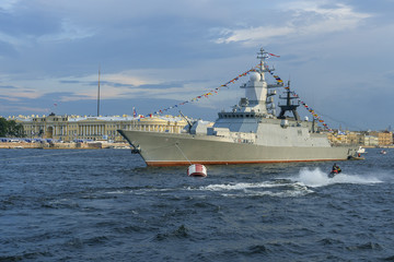 Naklejka premium military ship on Neva river in St. Petersburg against the blue sky and the city.