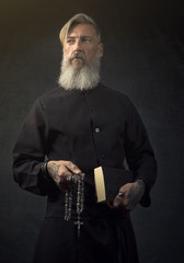 Portrait eines heiligen Priesters vor einem dunklen Hintergrund