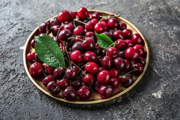 Plate with fresh ripe cherry on grunge background