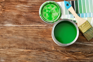 Can of paint and brush on wooden background