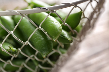 Basket with green pea pods on table, closeup