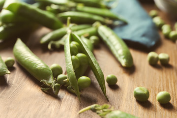 Fresh green peas on wooden table, closeup
