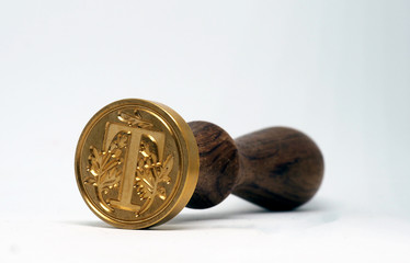  Stamp with letter T on white background.  Side view.