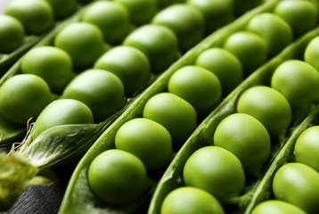 Pods with fresh green peas on table, closeup