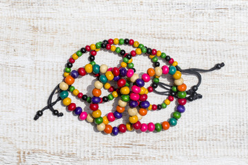 Colorful wooden beads bracelet on white wooden background