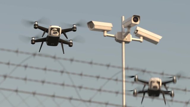 Security drones Modern surveillance technology flying behind barbed wire.