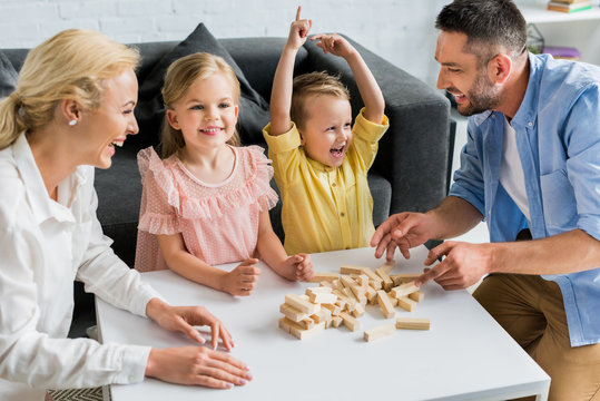 happy family playing with wooden blocks at home