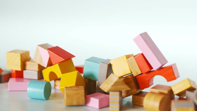 Construction of castle from colorful wooden blocks. Toy playful building.