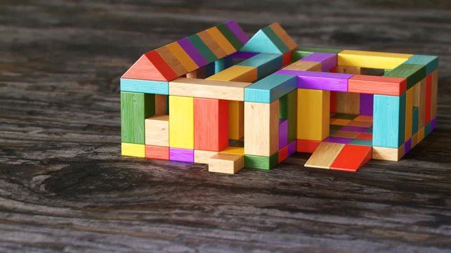 Toy house being built out of wooden blocks timelapse. Construction development.