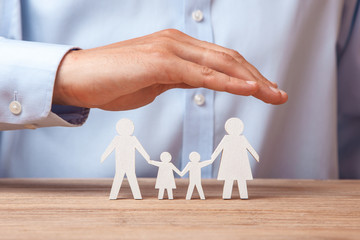 Medical or travel insurance. Man covers the family with his hands from his father, mother, son and daughter