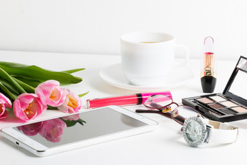 Fresh pink tulips, white tablet, cosmetics, wristwatch, cup of coffee, glasses - spring female things