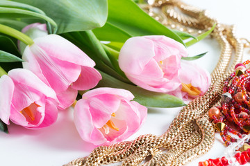 Pink fresh tulips with green leaves, different bijouterie - spring female things, close up