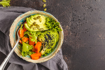 Vegan salad, rainbow bowl with baked sweet potato and avocado, top view, copy space. Healthy vegan food concept.