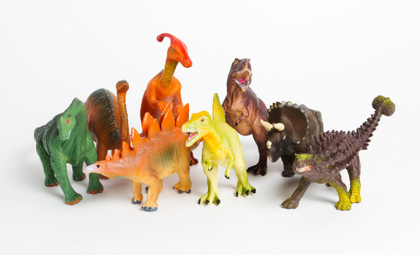 Eight different models of dinosaurs on white, children toys