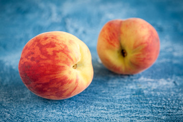 Fresh peaches on blue stone background