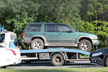 Broken car on tow truck after traffic accident, on the road service - 209676281