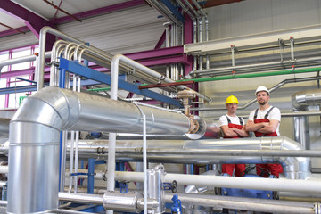 Gruppe Monteure in einer Industrieanlage am Arbeitsplatz // Group of fitters in an industrial plant...