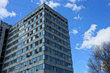 Obraz premium part of a large old gray house with windows on the sky background