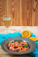 Fried shrimps with spicy orange sauce on wooden background