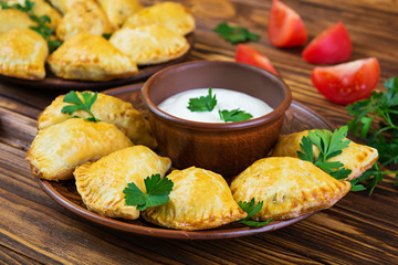 Delicious baked empanadas on wooden background