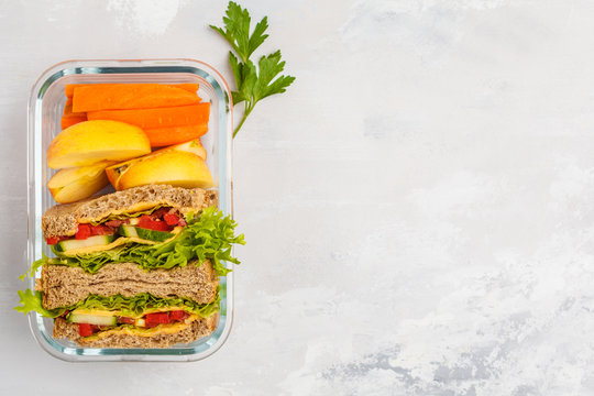 Healthy Meal Prep Container With Cheese Vegetable Sandwiches And Fruits Overhead Shot With Copy Space, Top View.