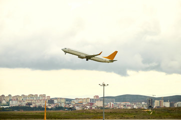 Plane flying above the clouds over airport ground and city view cloudy stormy sky Istambul Turkey travel tourism.
