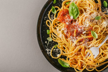Dark plate with italian spaghetti on grey