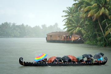 Monsoon time. People crossing a river by boat in rain - obrazy, fototapety, plakaty