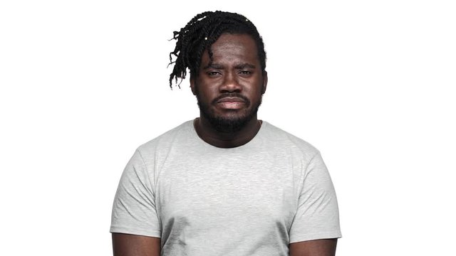 Portrait of amazed dark skinned guy with open mouth can't believe what happened and meaning it's unreal when shaking head, isolated over white background slow motion. Concept of emotions