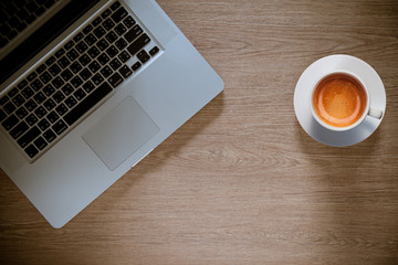 cup of coffee with laptop on wooden  table