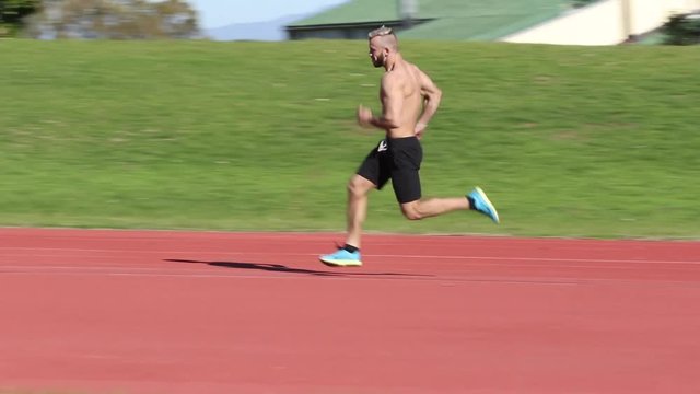 low angle shot of male jogger coming around a bend and running past camera on a mountain trail