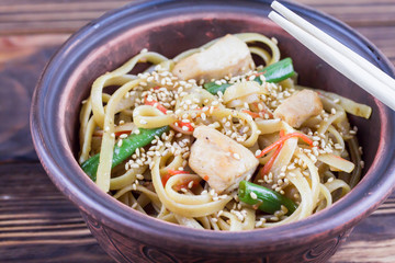 chinese noodles with chicken on wooden background