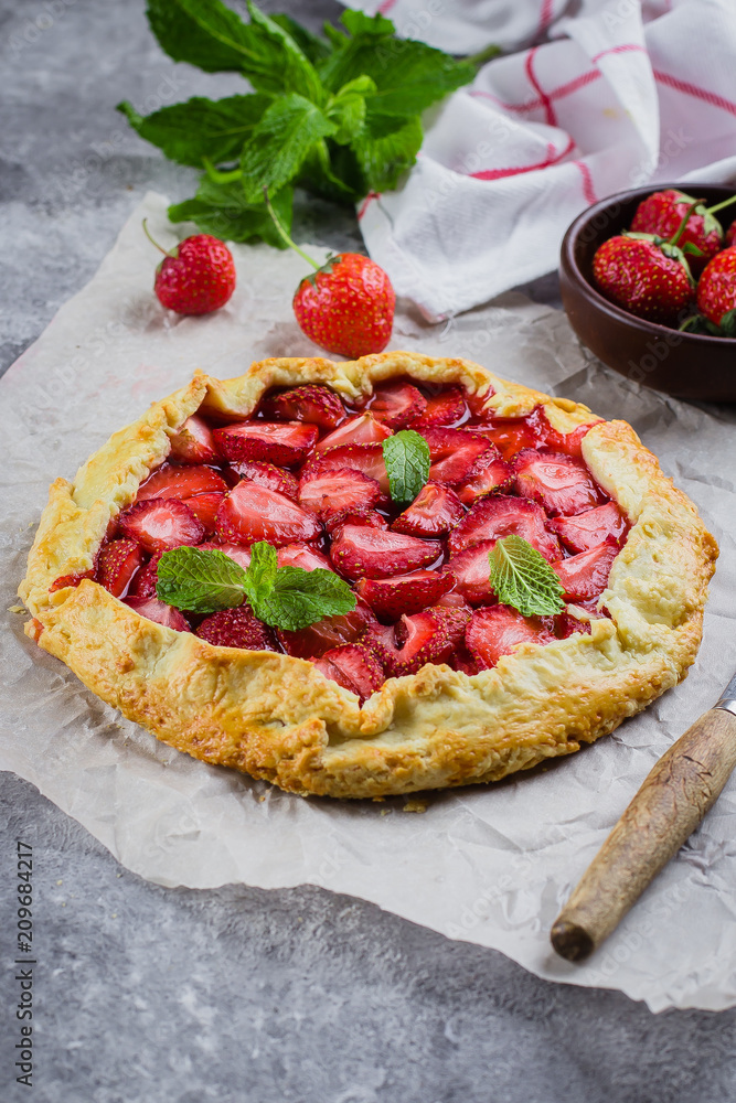 Wall mural galette with strawberry on the gray concrete stone background. vegetarian healthy berry tart decorat